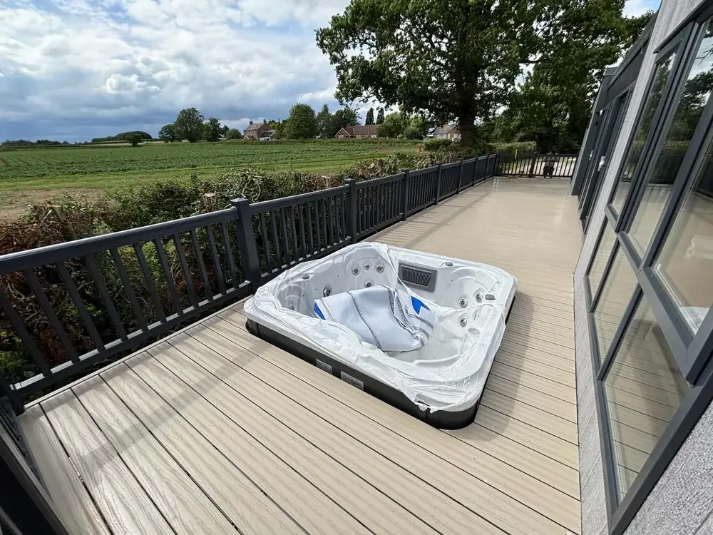 Wide composite deck with a white hot tub and balustrade